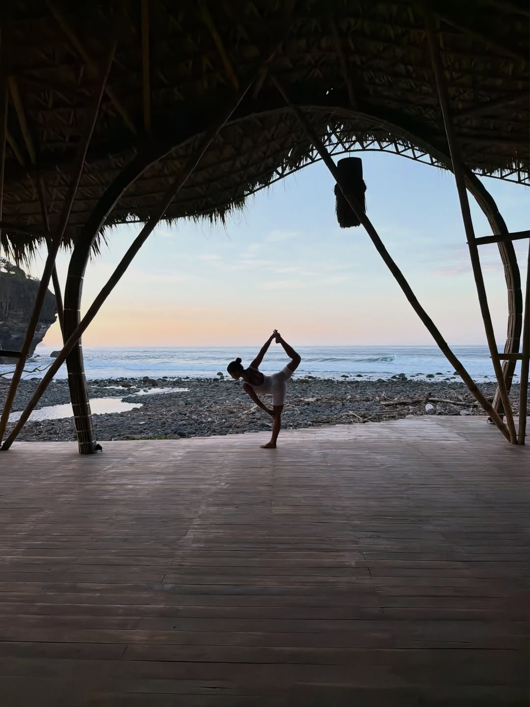 A guest practicing yoga on an open-air deck overlooking the Pacific